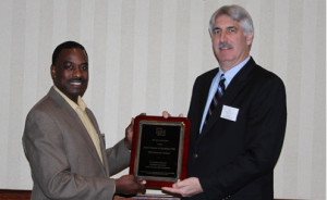 Photograph: Steve Toth (right) presenting plaque to Dr. Godfrey Nalyanya (left) during awards luncheon at annual meeting of the Southeastern Branch of the Entomological Society of America in Atlanta, Georgia. Photograph by Rosemary Hallberg.