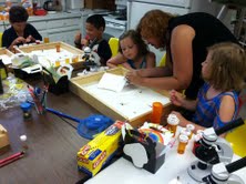 Eddie and Anthony Almanza, and Sarah and Samantha Mills mount insects with assistance from Insect Camp instructor Nicole Sanchez.