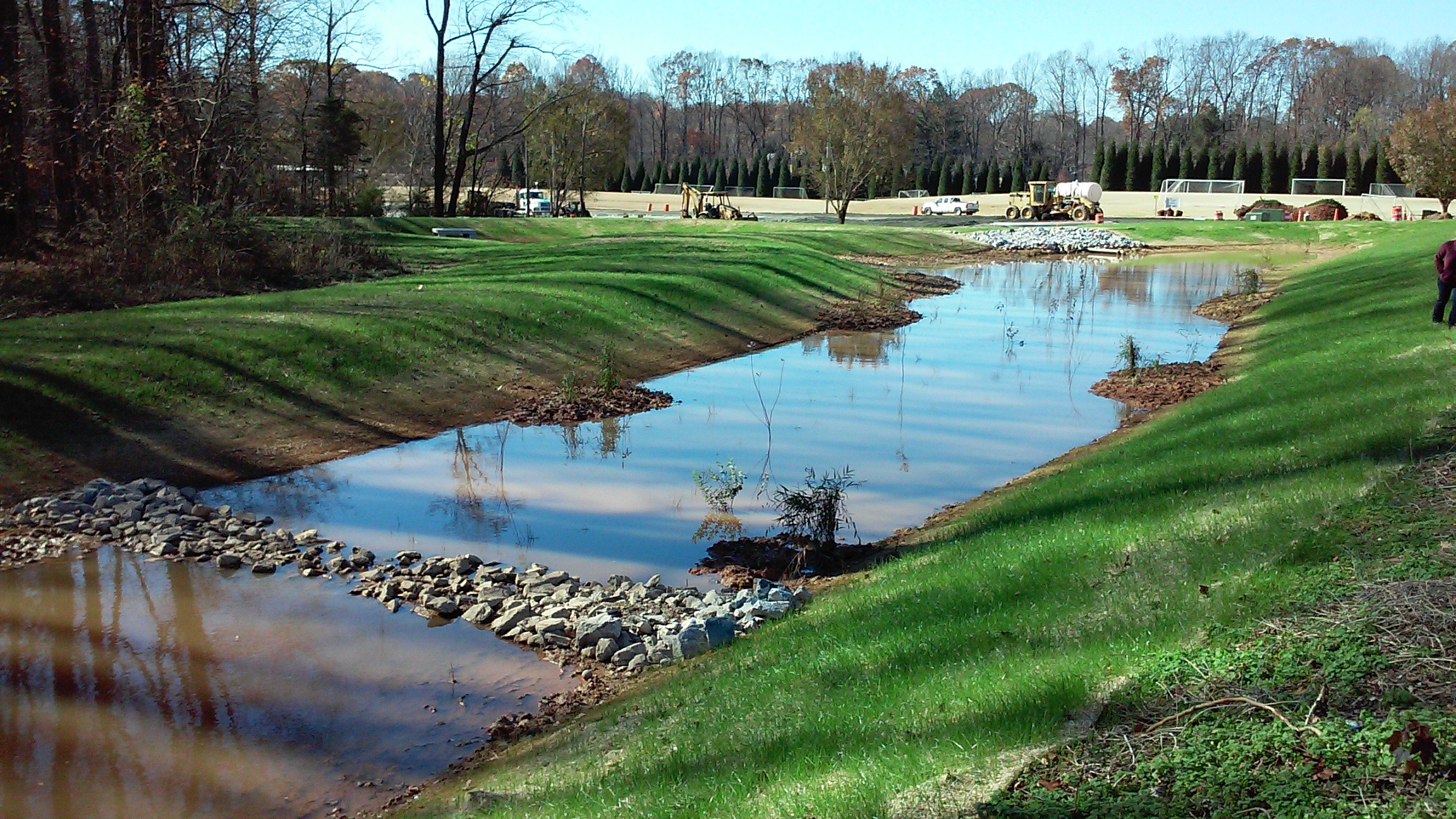 Built in late 2015 this stormwater wetland slows, spread, absorbs and disperses stormwater runoff from the upper parking lot. Watch for plants in May 2016!