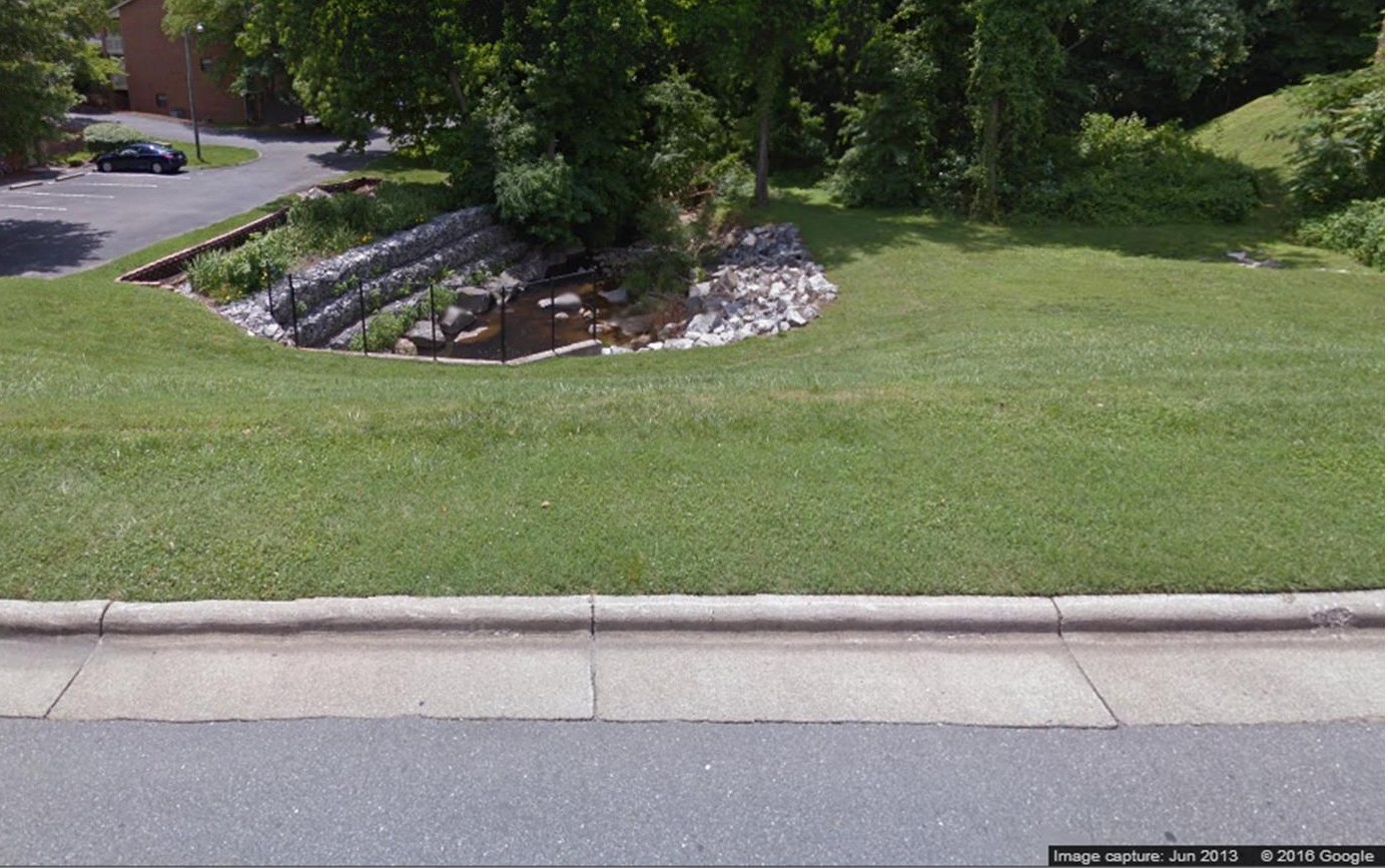 This site is across from the Kernersville Recycling Center. Many years ago the soil was caving in around the pipe the stream ran through and there were worries eventually the road would cave. The solution...a combination of a level spreader (much like a curb to spread out the rainwater) that flows into a bioretention cell backed by an armored bank of gabion baskets.