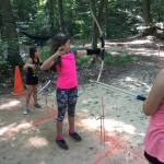 Aiva Nolan learns how to use a bow and arrow during archery.