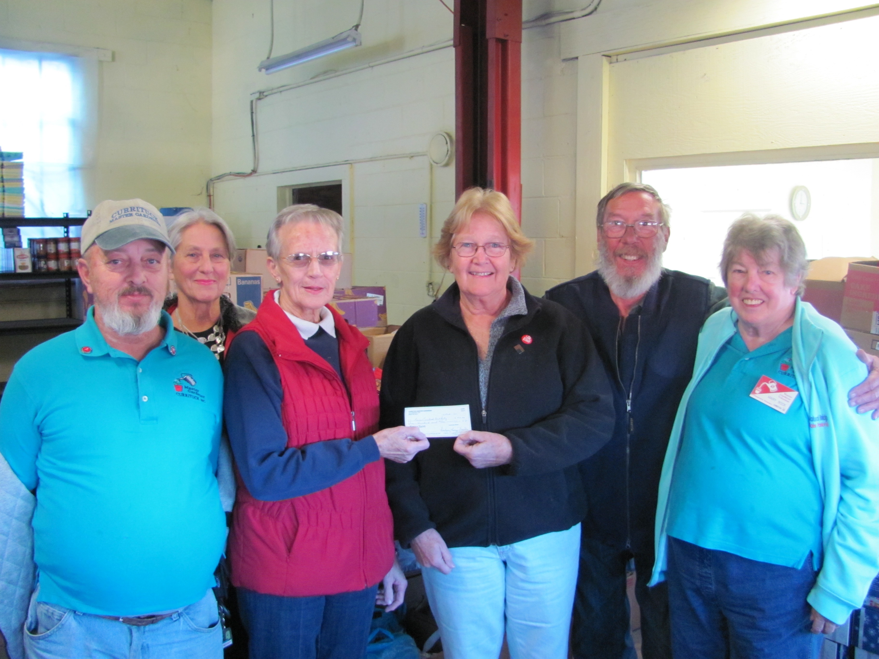 (From left to right) Fred Bock, Ann McNamee, Lower Currituck Food Bank Coordinator Polly Gregory, 2017 Master Gardener President Kerie O’Toole, Ken Ferguson, and Mary Bock.