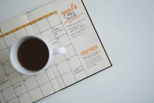 Coffee cup sitting on an open paper planner