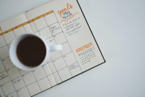 Coffee cup sitting on an open paper planner