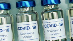 Vials of a COVID-19 vaccine are arranged side by side in a row.