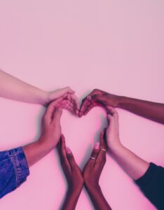 Hands of many ethnicites coming to gether to form a heart shape