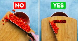tomatoes on cutting board being put in a bowl
