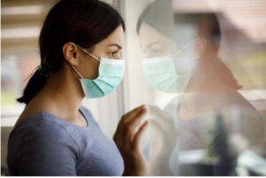 Teen With Mask Looking Through Glass