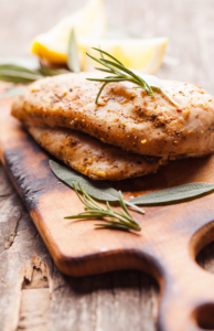 Baked Chicken Breasts with Herbs on a Cutting Board
