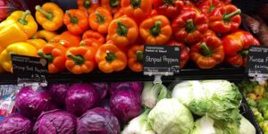 Orange, yellow, red striped bell peppers, purple and green cabbage