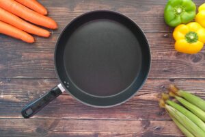 empty pan with vegetables surrounding it