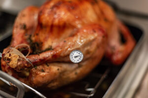 Using a meat thermometer to check if the turkey is cooked to the proper temperature