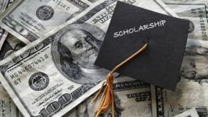 money with graduation cap and word "scholarship"