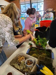 Lady and a girl getting a small plant for a terrarium
