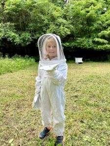 Junior beekeeper in bee suit
