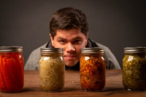 man looking at jars of fermented products