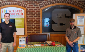 Alex Chouljenko and Greg Bolton standing at a booth providing information about seafood safety.