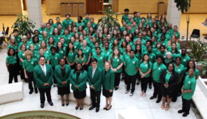Photo of all CNCF delegates in green shirts and black pants or skirts