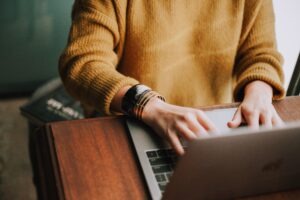 Aerial view of a woman typing on a laptop.