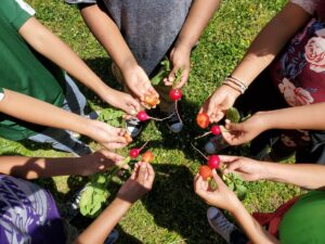children holding fruits and veggies in a circle