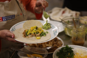 Picture of person with NC Cooperative Extension apron holding plate of food