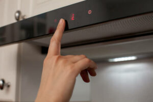 person turning on the fan above a stove.