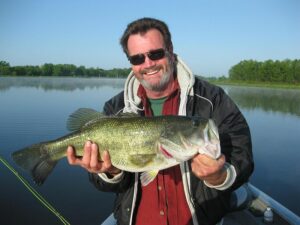 Man holding a freshly caught largemouth bass.