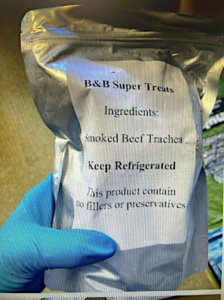 gloved hand holding foil package of B&B Super treats