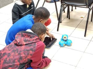 image of three boys coding a DASH Robot
