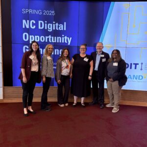 Six members of NC Cooperative Extension’s Digital Futures team standing together and smiling at the NC Digital Opportunity Gathering in April 2025.