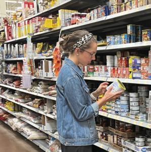 woman in grocery store looking at food item