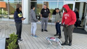 Alex Brown (left), a graduate student in NC State's Department of Biological and Agricultural Engineering, demonstrates a robot called Wolf Puppy to participants in the AI 101 training for Extension agents.