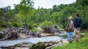 David Davis, director of the N.C. Cooperative Extension center in Yancey County, surveys the impact of Hurricane Helene on River Oak Farm in Burnsville, N.C., with owner Roger Young.