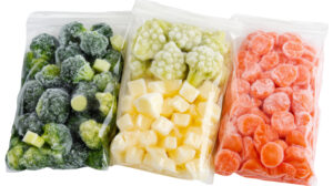 Frozen broccoli, cauliflower, and chopped carrots are stored in plastic bags
